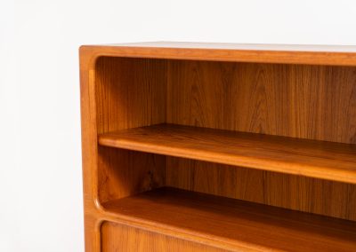 Beautiful bookcase in teak by Svend Dyrlund with tambour doors (Denmark, 1960s). This bookcase perfectly combines organic shapes and loads of details, like the tambour sliding doors, the beautiful handles or the bulky shelves, which are adjustable in height. It offers lots of storage space! In mint condition!