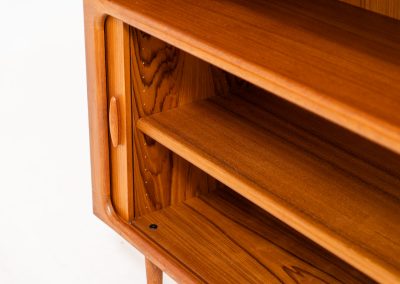 Beautiful bookcase in teak by Svend Dyrlund with tambour doors (Denmark, 1960s). This bookcase perfectly combines organic shapes and loads of details, like the tambour sliding doors, the beautiful handles or the bulky shelves, which are adjustable in height. It offers lots of storage space! In mint condition!