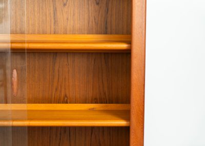 Stunning showcase by Svend Dyrlund (Denmark, 1960s). This exceptional piece features elegant glass doors with beautifully crafted wooden handles, two adjustable shelves, and convenient backlights behind each shelf to highlight your displayed items. Made from rich teak with a natural woodgrain, it perfectly combines functionality with the timeless characteristic of Danish modern design. In splendid condition.