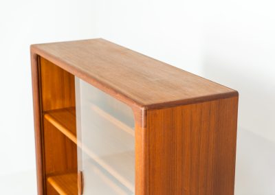 Stunning showcase by Svend Dyrlund (Denmark, 1960s). This exceptional piece features elegant glass doors with beautifully crafted wooden handles, two adjustable shelves, and convenient backlights behind each shelf to highlight your displayed items. Made from rich teak with a natural woodgrain, it perfectly combines functionality with the timeless characteristic of Danish modern design. In splendid condition.