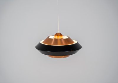Striking copper & black pendant light (Denmark, 1960s). This striking vintage pendant lamp features a refined combination of brushed copper and deep black lacquered metal. Its sculptural, UFO-inspired silhouette creates a warm, atmospheric glow while adding a bold design statement to any interior. The lamp is in very good condition!