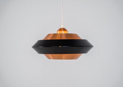 Striking copper & black pendant light (Denmark, 1960s). This striking vintage pendant lamp features a refined combination of brushed copper and deep black lacquered metal. Its sculptural, UFO-inspired silhouette creates a warm, atmospheric glow while adding a bold design statement to any interior. The lamp is in very good condition!