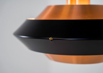 Striking copper & black pendant light (Denmark, 1960s). This striking vintage pendant lamp features a refined combination of brushed copper and deep black lacquered metal. Its sculptural, UFO-inspired silhouette creates a warm, atmospheric glow while adding a bold design statement to any interior. The lamp is in very good condition!