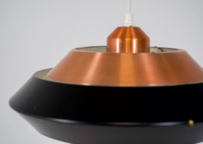 Striking copper & black pendant light (Denmark, 1960s). This striking vintage pendant lamp features a refined combination of brushed copper and deep black lacquered metal. Its sculptural, UFO-inspired silhouette creates a warm, atmospheric glow while adding a bold design statement to any interior. The lamp is in very good condition!