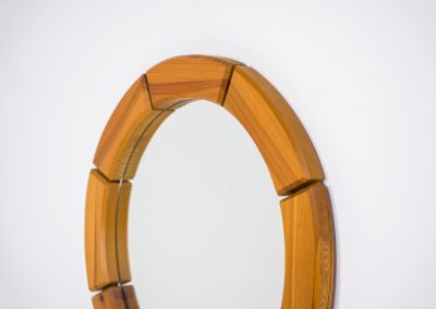 Sculptural wall-mirror in solid pine (Sweden, 1970s). This stunning Swedish mirror is crafted from solid pine, showcasing a bold and sculptural appearance. The mirror remains in excellent condition.