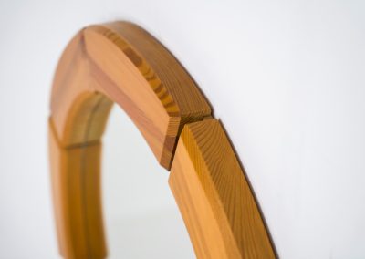 Sculptural wall-mirror in solid pine (Sweden, 1970s). This stunning Swedish mirror is crafted from solid pine, showcasing a bold and sculptural appearance. The mirror remains in excellent condition.