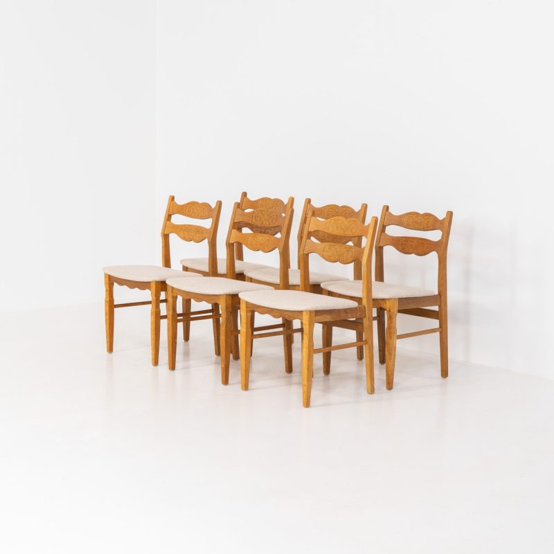 Set of 6 brutalist chairs in oak by Henning Kjaernulf (Denmark, 1970s). These brutalist dining chairs by Henning Kjaernulf have oak frames that display a beautifully matured patina that highlights the natural character of the wood. The seats have been newly upholstered in an off-white structured fabric, adding a fresh and refined contrast to the robust design. A timeless and highly collectible set that brings both presence and warmth to any interior.