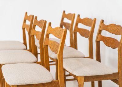 Set of 6 brutalist chairs in oak by Henning Kjaernulf (Denmark, 1970s). These brutalist dining chairs by Henning Kjaernulf have oak frames that display a beautifully matured patina that highlights the natural character of the wood. The seats have been newly upholstered in an off-white structured fabric, adding a fresh and refined contrast to the robust design. A timeless and highly collectible set that brings both presence and warmth to any interior.