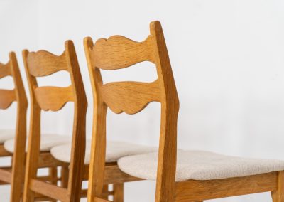 Set of 6 brutalist chairs in oak by Henning Kjaernulf (Denmark, 1970s). These brutalist dining chairs by Henning Kjaernulf have oak frames that display a beautifully matured patina that highlights the natural character of the wood. The seats have been newly upholstered in an off-white structured fabric, adding a fresh and refined contrast to the robust design. A timeless and highly collectible set that brings both presence and warmth to any interior.