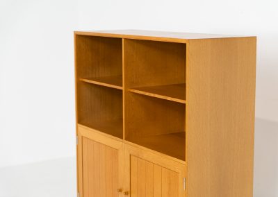 Oak bookcase by Rud Thygesen & Johnny Sørensen for HG furniture (Denmark, 1960s). It contains open shelves and two elegant doors with more shelves on the inside. The bookcase is in splendid condition.