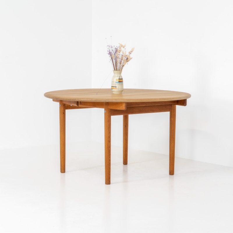 Magnificent PP70 extendable dining table by Hans J. Wegner for PP Møbler (Denmark, 1960s). This important and collectible piece designed by Hans J. Wegner, the grandmaster himself, is crafted out of solid oak and combines an extendable round tabletop with slender, slightly tapering legs. With two additional extensions, the length of the pp70 table can be increased up to 230 cm. Therefore, it makes an excellent choice for both small and large families. It’s in great condition with some slight color differences between the table top and the extension plates due to different UV exposures.