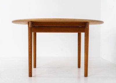 Magnificent PP70 extendable dining table by Hans J. Wegner for PP Møbler (Denmark, 1960s). This important and collectible piece designed by Hans J. Wegner, the grandmaster himself, is crafted out of solid oak and combines an extendable round tabletop with slender, slightly tapering legs. With two additional extensions, the length of the pp70 table can be increased up to 230 cm. Therefore, it makes an excellent choice for both small and large families. It’s in great condition with some slight color differences between the table top and the extension plates due to different UV exposures.