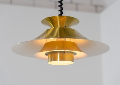 Brass colored pendant light by Frandsen (Denmark, 1970s). A beautiful lamp made out of four aluminium shades with a brass colored exterior. Featuring the original height-adjustable cord. The lamp remains in splendid condition.