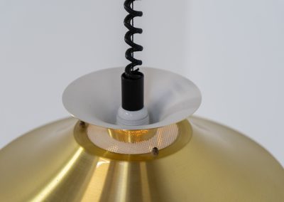 Brass colored pendant light by Frandsen (Denmark, 1970s). A beautiful lamp made out of four aluminium shades with a brass colored exterior. Featuring the original height-adjustable cord. The lamp remains in splendid condition.