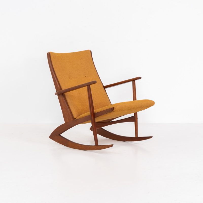 Stunning rocking chair by Georg Jensen for Kubus (Denmark, 1950s). This exceptional piece features a solid teak frame with beautiful organic lines and cushions that were recently reupholstered in an ocher yellow fabric. The chair is very comfortable, highly detailed and extremely beautiful.
