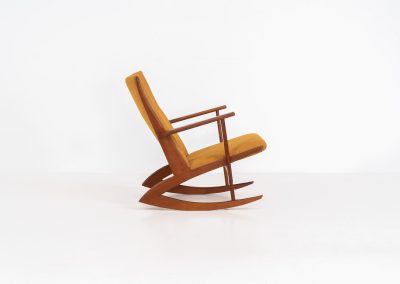 Stunning rocking chair by Georg Jensen for Kubus (Denmark, 1950s). This exceptional piece features a solid teak frame with beautiful organic lines and cushions that were recently reupholstered in an ocher yellow fabric. The chair is very comfortable, highly detailed and extremely beautiful.