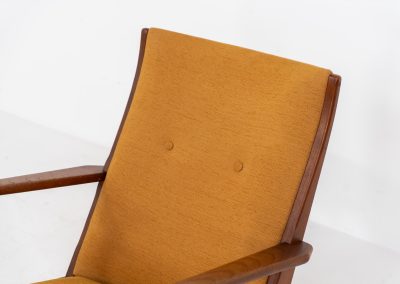 Stunning rocking chair by Georg Jensen for Kubus (Denmark, 1950s). This exceptional piece features a solid teak frame with beautiful organic lines and cushions that were recently reupholstered in an ocher yellow fabric. The chair is very comfortable, highly detailed and extremely beautiful.