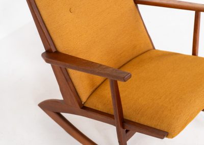 Stunning rocking chair by Georg Jensen for Kubus (Denmark, 1950s). This exceptional piece features a solid teak frame with beautiful organic lines and cushions that were recently reupholstered in an ocher yellow fabric. The chair is very comfortable, highly detailed and extremely beautiful.