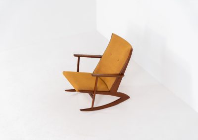 Stunning rocking chair by Georg Jensen for Kubus (Denmark, 1950s). This exceptional piece features a solid teak frame with beautiful organic lines and cushions that were recently reupholstered in an ocher yellow fabric. The chair is very comfortable, highly detailed and extremely beautiful.