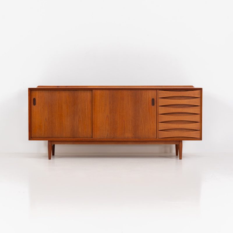 Rare “OS29” sideboard by Arne Vodder for Sibast (Denmark, 1950s). This highly important and collectible masterpiece by Arne Vodder is a rarity to find in good condition. The OS29 has perfect proportions, beautiful aesthetics and a high quality finish. It is crafted out of teak and features a turnable black door, 5 bow tie shaped drawers, adjustable shelves and a raised back edge. This piece remains in very good condition with a few small repair marks and using traces, as shown on the pictures. It is marked and stamped by the maker.
