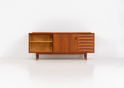 Rare “OS29” sideboard by Arne Vodder for Sibast (Denmark, 1950s). This highly important and collectible masterpiece by Arne Vodder is a rarity to find in good condition. The OS29 has perfect proportions, beautiful aesthetics and a high quality finish. It is crafted out of teak and features a turnable black door, 5 bow tie shaped drawers, adjustable shelves and a raised back edge. This piece remains in very good condition with a few small repair marks and using traces, as shown on the pictures. It is marked and stamped by the maker.