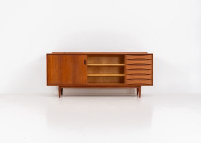 Rare “OS29” sideboard by Arne Vodder for Sibast (Denmark, 1950s). This highly important and collectible masterpiece by Arne Vodder is a rarity to find in good condition. The OS29 has perfect proportions, beautiful aesthetics and a high quality finish. It is crafted out of teak and features a turnable black door, 5 bow tie shaped drawers, adjustable shelves and a raised back edge. This piece remains in very good condition with a few small repair marks and using traces, as shown on the pictures. It is marked and stamped by the maker.