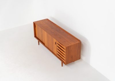 Rare “OS29” sideboard by Arne Vodder for Sibast (Denmark, 1950s). This highly important and collectible masterpiece by Arne Vodder is a rarity to find in good condition. The OS29 has perfect proportions, beautiful aesthetics and a high quality finish. It is crafted out of teak and features a turnable black door, 5 bow tie shaped drawers, adjustable shelves and a raised back edge. This piece remains in very good condition with a few small repair marks and using traces, as shown on the pictures. It is marked and stamped by the maker.
