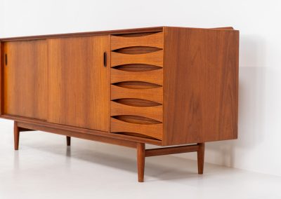 Rare “OS29” sideboard by Arne Vodder for Sibast (Denmark, 1950s). This highly important and collectible masterpiece by Arne Vodder is a rarity to find in good condition. The OS29 has perfect proportions, beautiful aesthetics and a high quality finish. It is crafted out of teak and features a turnable black door, 5 bow tie shaped drawers, adjustable shelves and a raised back edge. This piece remains in very good condition with a few small repair marks and using traces, as shown on the pictures. It is marked and stamped by the maker.