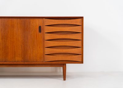 Rare “OS29” sideboard by Arne Vodder for Sibast (Denmark, 1950s). This highly important and collectible masterpiece by Arne Vodder is a rarity to find in good condition. The OS29 has perfect proportions, beautiful aesthetics and a high quality finish. It is crafted out of teak and features a turnable black door, 5 bow tie shaped drawers, adjustable shelves and a raised back edge. This piece remains in very good condition with a few small repair marks and using traces, as shown on the pictures. It is marked and stamped by the maker.