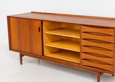 Rare “OS29” sideboard by Arne Vodder for Sibast (Denmark, 1950s). This highly important and collectible masterpiece by Arne Vodder is a rarity to find in good condition. The OS29 has perfect proportions, beautiful aesthetics and a high quality finish. It is crafted out of teak and features a turnable black door, 5 bow tie shaped drawers, adjustable shelves and a raised back edge. This piece remains in very good condition with a few small repair marks and using traces, as shown on the pictures. It is marked and stamped by the maker.