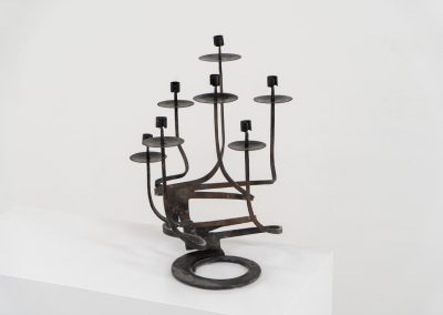 Stunning brutalist candelabra in the manner of Jean Touret for Arelier Marolles (France, 1950s). A highly sculptural cast iron candelabra featuring seven candle holders and a stunning patina.