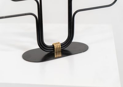 Elegant candelabra in brass and metal by Gunnar Ander for Ystad-Metal (Sweden, 1950s). This refined candelabra features slender, black-lacquered bent metal supports combined with solid brass candle holders, creating a striking contrast. The piece is in very good vintage condition. The brass shows a beautiful, even patina that enhances its character and authenticity. Marked by maker.