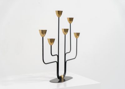 Elegant candelabra in brass and metal by Gunnar Ander for Ystad-Metal (Sweden, 1950s). This refined candelabra features slender, black-lacquered bent metal supports combined with solid brass candle holders, creating a striking contrast. The piece is in very good vintage condition. The brass shows a beautiful, even patina that enhances its character and authenticity. Marked by maker.