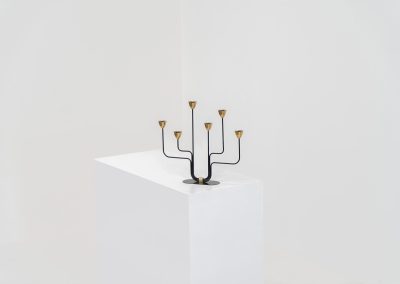 Elegant candelabra in brass and metal by Gunnar Ander for Ystad-Metal (Sweden, 1950s). This refined candelabra features slender, black-lacquered bent metal supports combined with solid brass candle holders, creating a striking contrast. The piece is in very good vintage condition. The brass shows a beautiful, even patina that enhances its character and authenticity. Marked by maker.