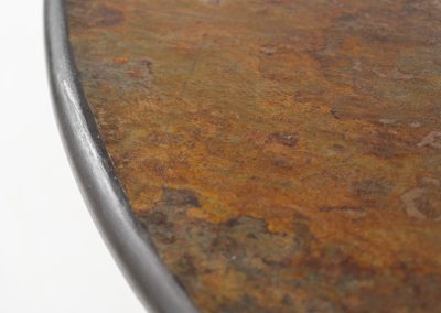 Brutalist coffee table by C. Kneip (Germany, 1990s). A powerful and sculptural brutalist coffee table by German designer C. Kneip, dating from the 1990s. The design is defined by its expressive materiality and architectural presence. The substantial tabletop is crafted from Indian slate and enriched with inlaid elements of lava stone, copper, and brass. These materials are arranged in a richly textured, almost relief-like composition, creating a striking interplay of color, surface, and depth. The heavy stone top is supported by a black lacquered wooden base, providing a sense of grounded solidity. The table is marked by the maker and retains its original certificate. Presented in splendid condition.