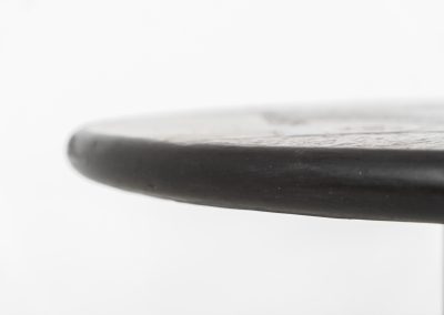 Brutalist coffee table by C. Kneip (Germany, 1990s). A powerful and sculptural brutalist coffee table by German designer C. Kneip, dating from the 1990s. The design is defined by its expressive materiality and architectural presence. The substantial tabletop is crafted from Indian slate and enriched with inlaid elements of lava stone, copper, and brass. These materials are arranged in a richly textured, almost relief-like composition, creating a striking interplay of color, surface, and depth. The heavy stone top is supported by a black lacquered wooden base, providing a sense of grounded solidity. The table is marked by the maker and retains its original certificate. Presented in splendid condition.