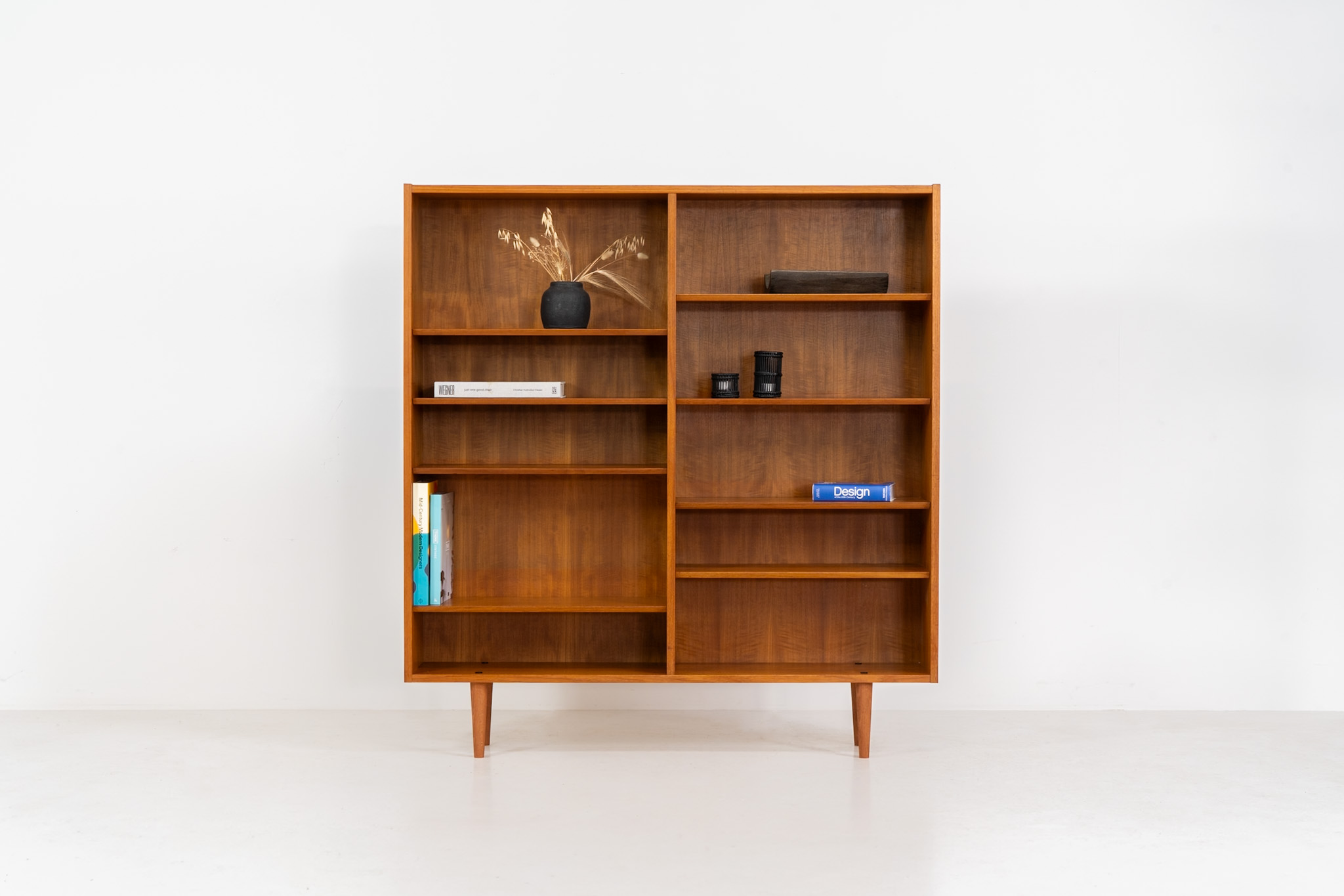 Midcentury bookcase by Poul Hundevad (Denmark, 1960s). A simple and well-built piece in teak designed by the renowned Poul Hundevad. It contains eight adjustable shelves with beveled edges and has an amazing natural woodgrain. In excellent condition and labeled by maker. We have a second one available aswel with different proportions.