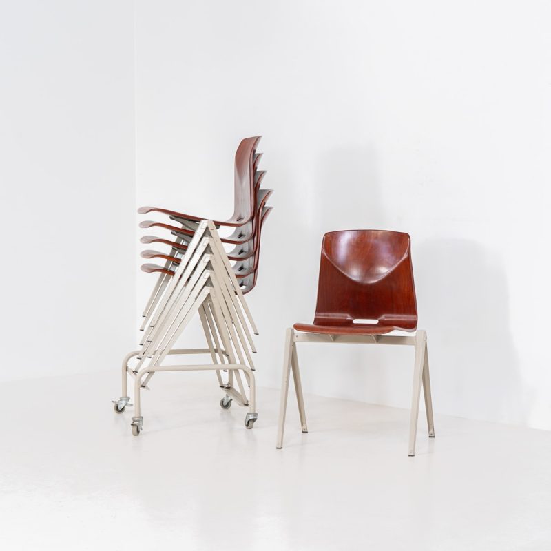 Set of 6 “S22” industrial dining chairs by Elmar Flototto for Pagholz (Germany, 1960s). This set of six original S22 industrial dining chairs, designed by Elmar Flötotto for Pagholz, dates from the 1960s and was produced in Germany. The chairs feature a rare and highly sought-after combination of rosewood-toned moulded Pagholz seats paired with crème powder-coated steel frames. Their clean, functional design reflects the strong industrial aesthetic Pagholz is known for. All chairs are fully stackable and come with the original stacking trolley, a seldom-found and highly desirable addition. The set is in very good vintage condition, showing only minor signs of wear consistent with age and use, without structural issues. A timeless and characterful set, suitable for both dining and contract interiors, and a strong example of post-war German industrial design.