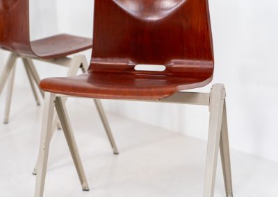 Set of 6 “S22” industrial dining chairs by Elmar Flototto for Pagholz (Germany, 1960s). This set of six original S22 industrial dining chairs, designed by Elmar Flötotto for Pagholz, dates from the 1960s and was produced in Germany. The chairs feature a rare and highly sought-after combination of rosewood-toned moulded Pagholz seats paired with crème powder-coated steel frames. Their clean, functional design reflects the strong industrial aesthetic Pagholz is known for. All chairs are fully stackable and come with the original stacking trolley, a seldom-found and highly desirable addition. The set is in very good vintage condition, showing only minor signs of wear consistent with age and use, without structural issues. A timeless and characterful set, suitable for both dining and contract interiors, and a strong example of post-war German industrial design.