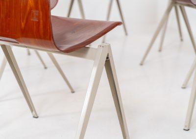 Set of 6 “S22” industrial dining chairs by Elmar Flototto for Pagholz (Germany, 1960s). This set of six original S22 industrial dining chairs, designed by Elmar Flötotto for Pagholz, dates from the 1960s and was produced in Germany. The chairs feature a rare and highly sought-after combination of rosewood-toned moulded Pagholz seats paired with crème powder-coated steel frames. Their clean, functional design reflects the strong industrial aesthetic Pagholz is known for. All chairs are fully stackable and come with the original stacking trolley, a seldom-found and highly desirable addition. The set is in very good vintage condition, showing only minor signs of wear consistent with age and use, without structural issues. A timeless and characterful set, suitable for both dining and contract interiors, and a strong example of post-war German industrial design.