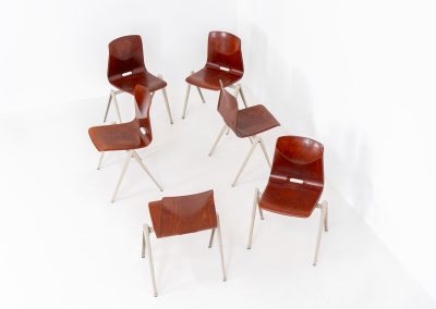 Set of 6 “S22” industrial dining chairs by Elmar Flototto for Pagholz (Germany, 1960s). This set of six original S22 industrial dining chairs, designed by Elmar Flötotto for Pagholz, dates from the 1960s and was produced in Germany. The chairs feature a rare and highly sought-after combination of rosewood-toned moulded Pagholz seats paired with crème powder-coated steel frames. Their clean, functional design reflects the strong industrial aesthetic Pagholz is known for. All chairs are fully stackable and come with the original stacking trolley, a seldom-found and highly desirable addition. The set is in very good vintage condition, showing only minor signs of wear consistent with age and use, without structural issues. A timeless and characterful set, suitable for both dining and contract interiors, and a strong example of post-war German industrial design.