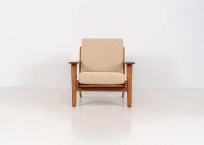 Early GE-290 lounge chair in oak by Hans J. Wegner for Getama (Denmark, 1953). An iconic early example of Hans J. Wegner's GE-290 lounge chair, produced by Getama in Denmark in 1953. This celebrated design is renowned for its sculptural yet restrained form and exceptional comfort. The chair features a dark-stained solid oak frame paired with beige wool cushions, creating a timeless and well-balanced contrast that highlights Wegner's mastery of materials and proportion. Presented in splendid condition, with the frame and upholstery beautifully preserved. We also have a GE290A + ottoman and a GE290 3-seater available in stock.