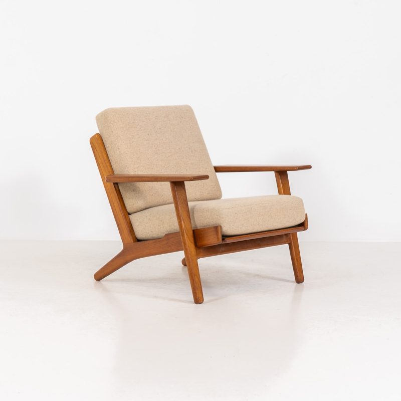 Early GE-290 lounge chair in oak by Hans J. Wegner for Getama (Denmark, 1953). An iconic early example of Hans J. Wegner's GE-290 lounge chair, produced by Getama in Denmark in 1953. This celebrated design is renowned for its sculptural yet restrained form and exceptional comfort. The chair features a dark-stained solid oak frame paired with beige wool cushions, creating a timeless and well-balanced contrast that highlights Wegner's mastery of materials and proportion. Presented in splendid condition, with the frame and upholstery beautifully preserved. We also have a GE290A + ottoman and a GE290 3-seater available in stock.