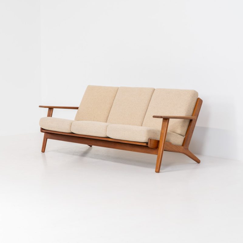 Early GE-290 3-seater sofa in oak by Hans J. Wegner for Getama (Denmark, 1953). An iconic early example of Hans J. Wegner's GE-290 , produced by Getama in Denmark in 1953. This celebrated design is renowned for its sculptural yet restrained form and exceptional comfort. The sofa features a dark-stained solid oak frame paired with beige wool cushions, creating a timeless and well-balanced contrast that highlights Wegner's mastery of materials and proportion. Presented in splendid condition, with the frame and upholstery beautifully preserved. We also have a GE290A + ottoman and a GE290 lounge chair available in stock.