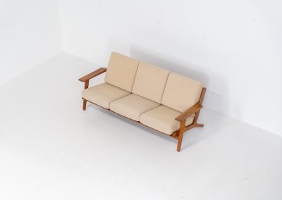 Early GE-290 3-seater sofa in oak by Hans J. Wegner for Getama (Denmark, 1953). An iconic early example of Hans J. Wegner's GE-290 , produced by Getama in Denmark in 1953. This celebrated design is renowned for its sculptural yet restrained form and exceptional comfort. The sofa features a dark-stained solid oak frame paired with beige wool cushions, creating a timeless and well-balanced contrast that highlights Wegner's mastery of materials and proportion. Presented in splendid condition, with the frame and upholstery beautifully preserved. We also have a GE290A + ottoman and a GE290 lounge chair available in stock.