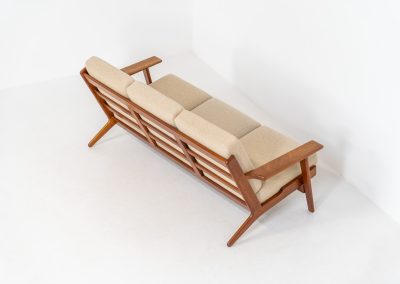 Early GE-290 3-seater sofa in oak by Hans J. Wegner for Getama (Denmark, 1953). An iconic early example of Hans J. Wegner's GE-290 , produced by Getama in Denmark in 1953. This celebrated design is renowned for its sculptural yet restrained form and exceptional comfort. The sofa features a dark-stained solid oak frame paired with beige wool cushions, creating a timeless and well-balanced contrast that highlights Wegner's mastery of materials and proportion. Presented in splendid condition, with the frame and upholstery beautifully preserved. We also have a GE290A + ottoman and a GE290 lounge chair available in stock.