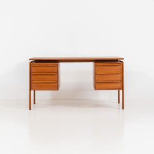 Teak writing desk by Arne Vodder for G.V. Møbler (Denmark, 1960s). This exceptionally beautiful piece is a true example of top-quality Danish craftsmanship. Made from teak, it showcases elegant aesthetics with softly rounded edges and a floating desk top. It contains six very deep drawers and a finished backside, making it an ideal piece for placement in the center of a room. The desk is in excellent condition.