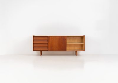 Teak sideboard by Nils Jonsson for Hugo Troeds (Sweden, 1950s). Elegant sideboard by Swedish designer Nils Jonsson, executed in warm teak. The clean, architectural form is complemented by tapered legs and balanced proportions. A distinctive feature of this piece is the set of sculpted, stepped drawers, offering both visual rhythm and practical storage. Sliding doors reveal generous interior space, making the sideboard as functional as it is refined. A timeless example of Scandinavian modern design, presented in excellent vintage condition.