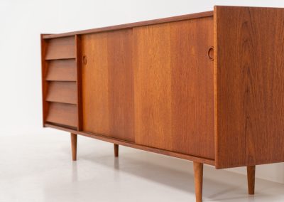 Teak sideboard by Nils Jonsson for Hugo Troeds (Sweden, 1950s). Elegant sideboard by Swedish designer Nils Jonsson, executed in warm teak. The clean, architectural form is complemented by tapered legs and balanced proportions. A distinctive feature of this piece is the set of sculpted, stepped drawers, offering both visual rhythm and practical storage. Sliding doors reveal generous interior space, making the sideboard as functional as it is refined. A timeless example of Scandinavian modern design, presented in excellent vintage condition.