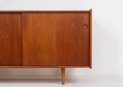 Teak sideboard by Nils Jonsson for Hugo Troeds (Sweden, 1950s). Elegant sideboard by Swedish designer Nils Jonsson, executed in warm teak. The clean, architectural form is complemented by tapered legs and balanced proportions. A distinctive feature of this piece is the set of sculpted, stepped drawers, offering both visual rhythm and practical storage. Sliding doors reveal generous interior space, making the sideboard as functional as it is refined. A timeless example of Scandinavian modern design, presented in excellent vintage condition.